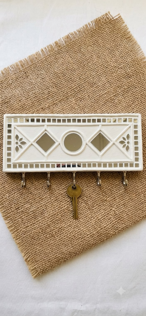 Kunjika — 11x2-Inch Handcrafted Lippan 5-Hook Keyholder — handmade hand-sculpted white clay relief, geometric mirror inlay, and 5 metal hooks on wooden plaque by Rachna Saxena