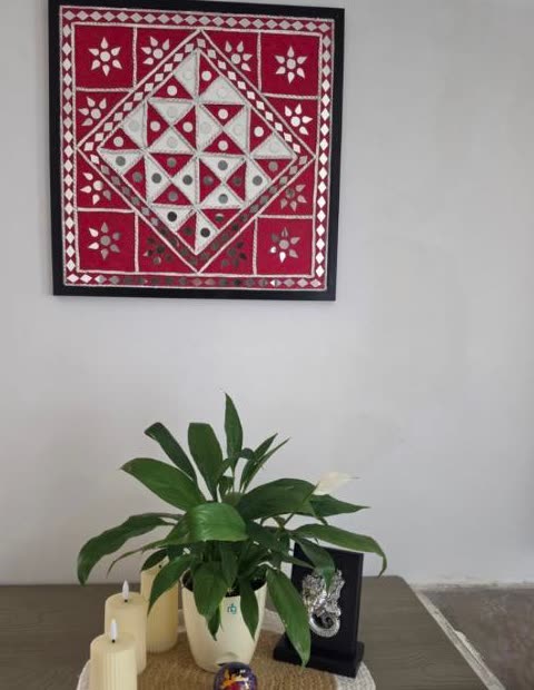Customer photo of a framed red and white Lippan mirror wall artwork by Rachna Saxena in their home