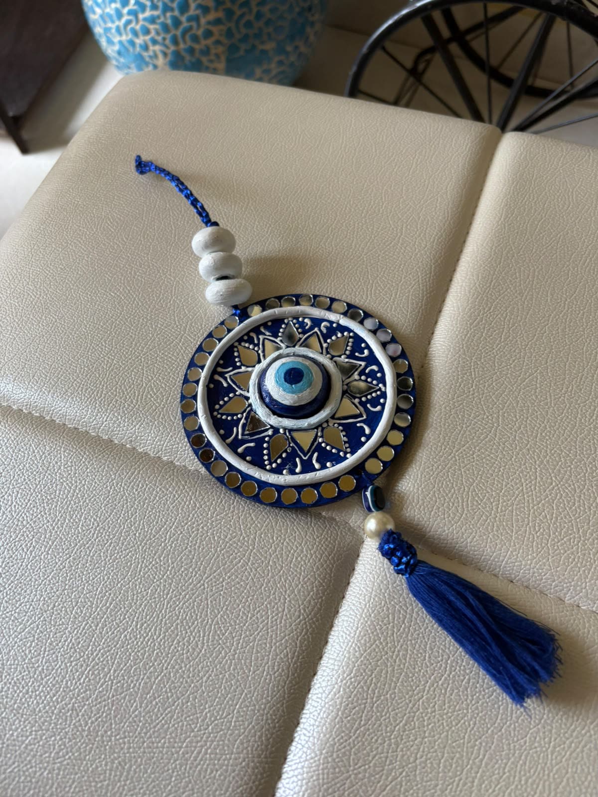 Nazar Raksha — 6-Inch Lippan Evil Eye Hanging — handmade royal-blue base with clay relief evil eye, hand-cut mirror ring, clay beads & blue silk tassel by Rachna Saxena